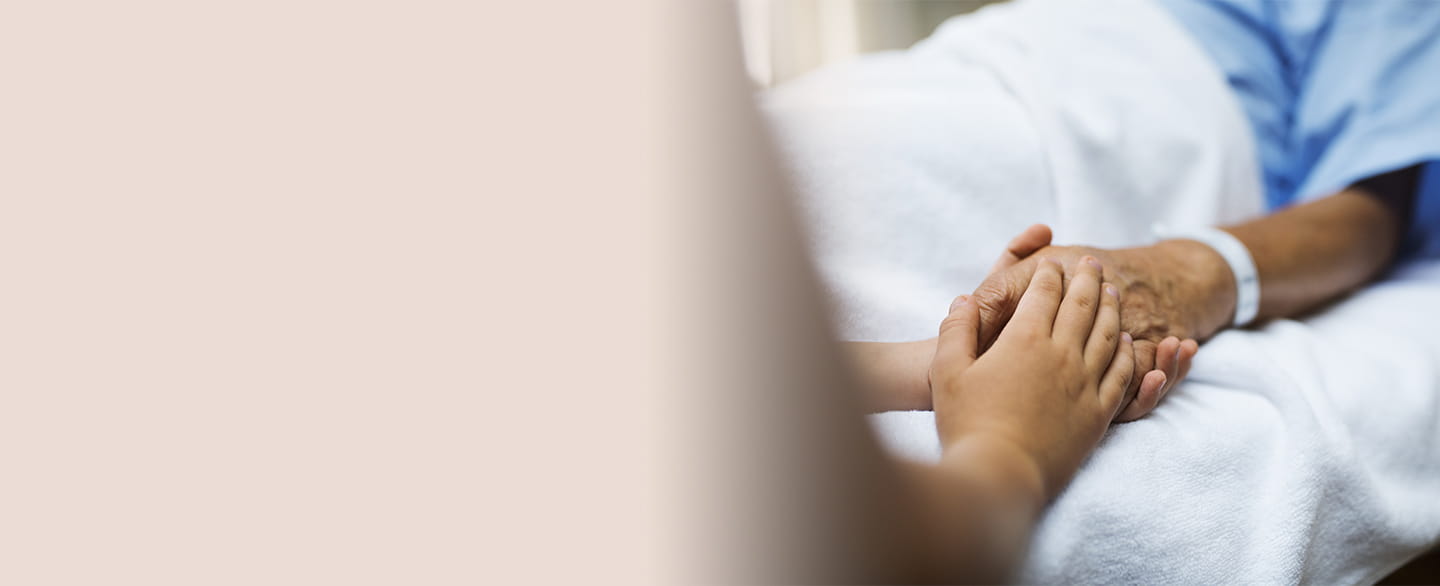 Provider holding hand of sick patient.