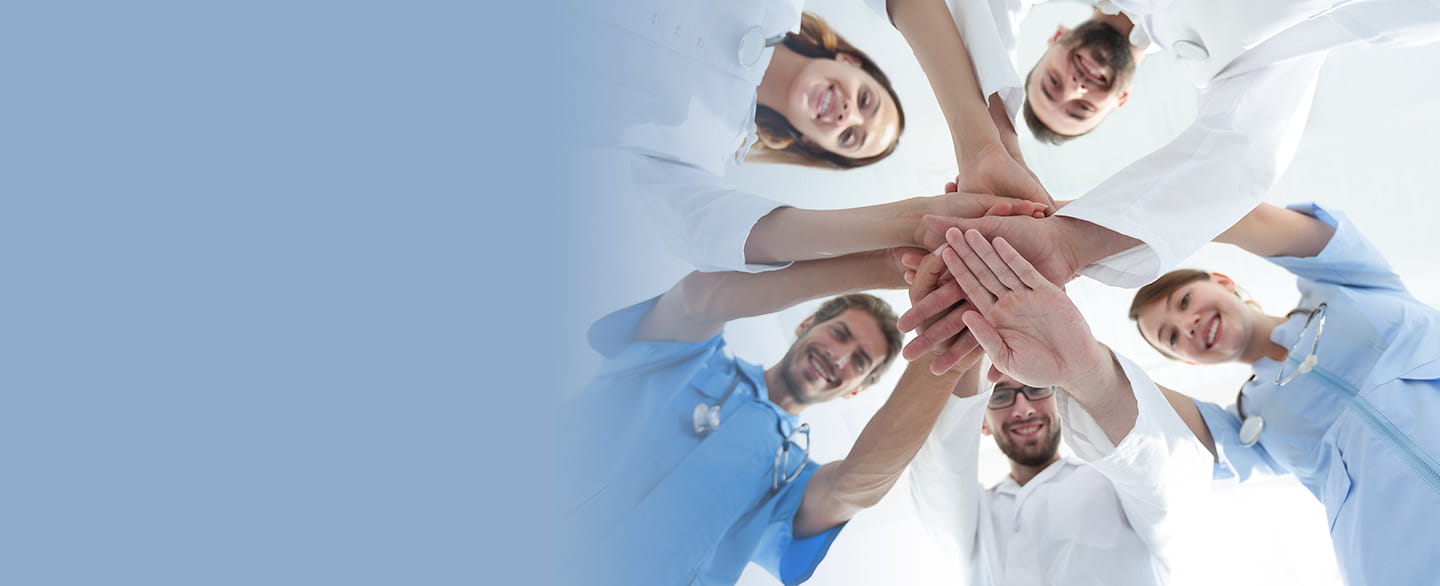Medical staff in a huddle with hands in
